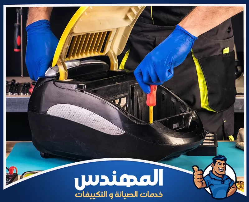 إصلاح ضعف شفط الغبار في حفر الباطن 0546176127 شركة المهندس رجل يرتدي قفازات زرقاء يستخدم مكنسة كهربائية في موقع صيانة في حفر الباطن.