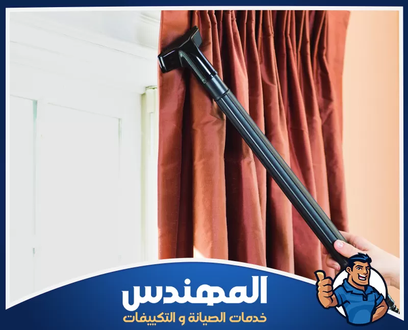 تنظيف ستائر الشيفون بحفر الباطن 0546176127 شركة المهندس شخص ينظف ستائر باستخدام مكنسة في حفر الباطن.