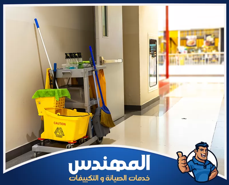 تنظيف أرضيات المحلات بحفر الباطن 0546176127 شركة المهندس عربة تنظيف تحتوي على ممسحة ودلو في منتصف ممر، تُستخدم لتنظيف المحلات التجارية في حفر الباطن.
