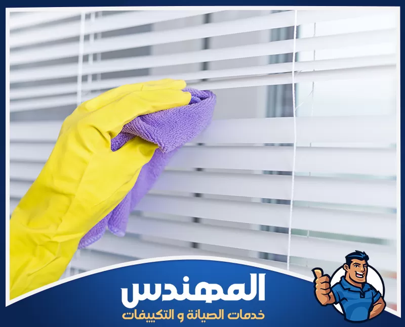 تنظيف ستائر المخمل بحفر الباطن 0546176127 شركة المهندس شخص ينظف الستائر باستخدام قفاز أصفر في حفر الباطن.