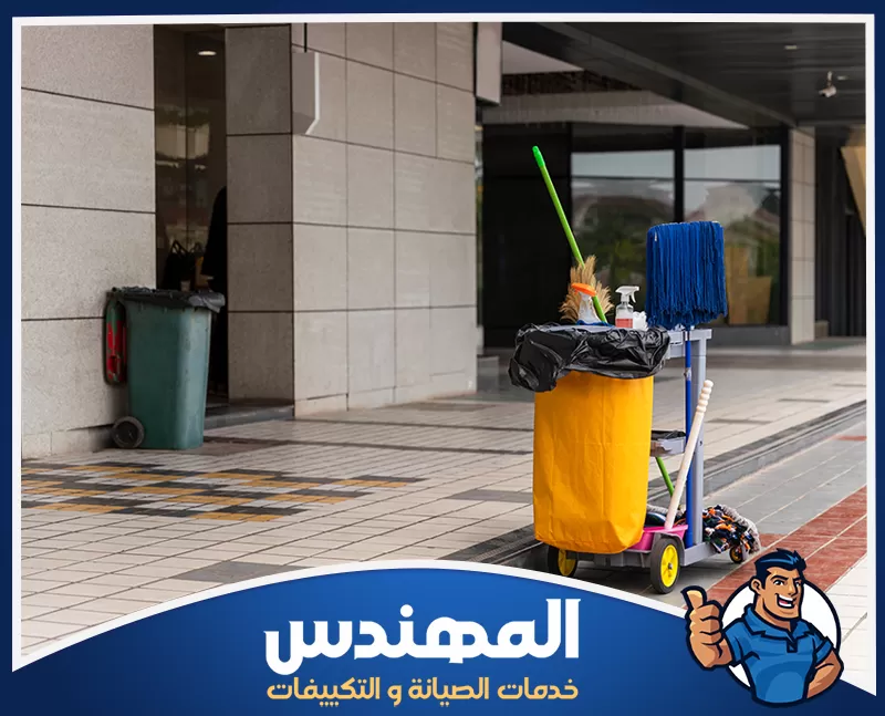 تنظيف الواجهات الزجاجية واللافتات للمحلات بحفر الباطن 0546176127 شركة المهندس رجل أمام مبنى مع عربة تنظيف، يقوم بتنظيف المحلات التجارية في حفر الباطن.