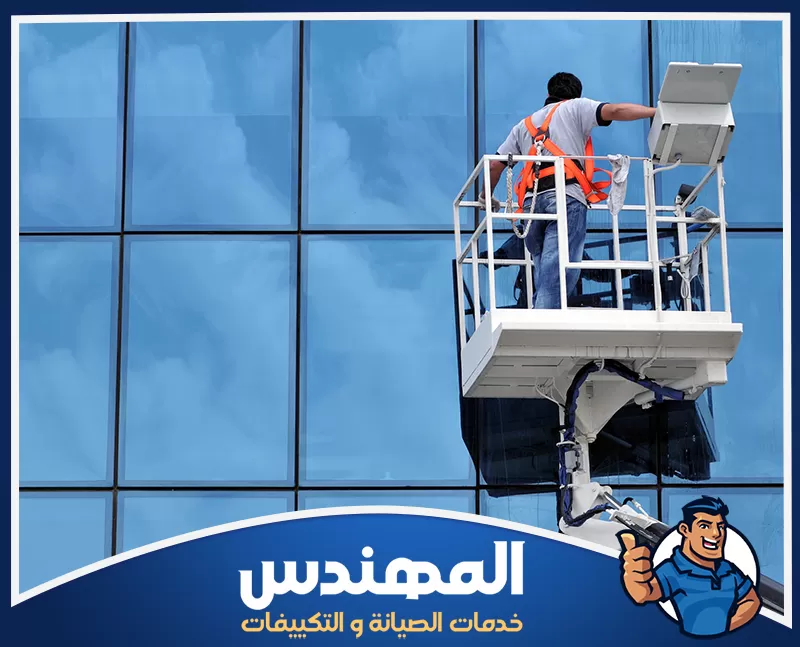 تنظيف الزجاج الخارجي للمباني بحفر الباطن 0546176127 شركة المهندس عامل يستخدم رافعة لتنظيف زجاج نوافذ مبنى خارجي في حفر الباطن.