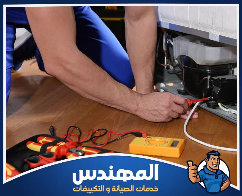 تصليح ضعف التبريد في الثلاجات بحفر الباطن 0546176127 شركة المهندس رجل يقوم بصيانة ثلاجة باستخدام أداة في حفر الباطن.