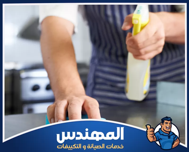 تنظيف مطابخ المطاعم بحفر الباطن 0546176127 شركة المهندس شخص ينظف سطح طاولة بمسحة، في مطبخ مطعم بحفر الباطن.