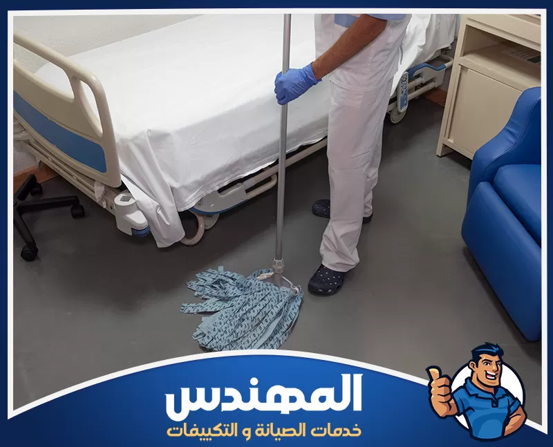 تعقيم مستشفيات في حفر الباطن 0546176127 شركة المهندس رجل يرتدي قفازات زرقاء يقوم بتنظيف سرير مستشفى في حفر الباطن.