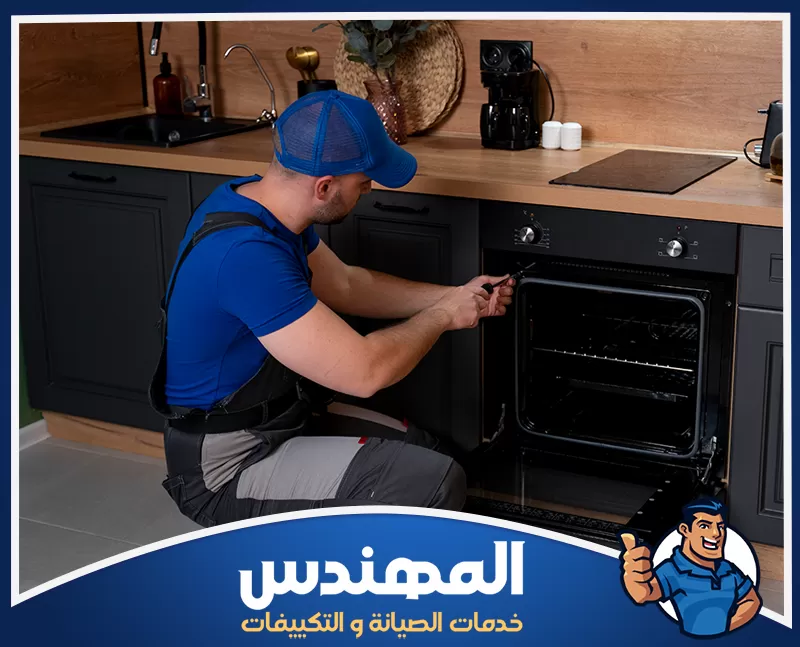 فني صيانة أفران بحفر الباطن أثناء إصلاح فرن منزلي فني يقوم بإصلاح فرن داخل المنزل في حفر الباطن
