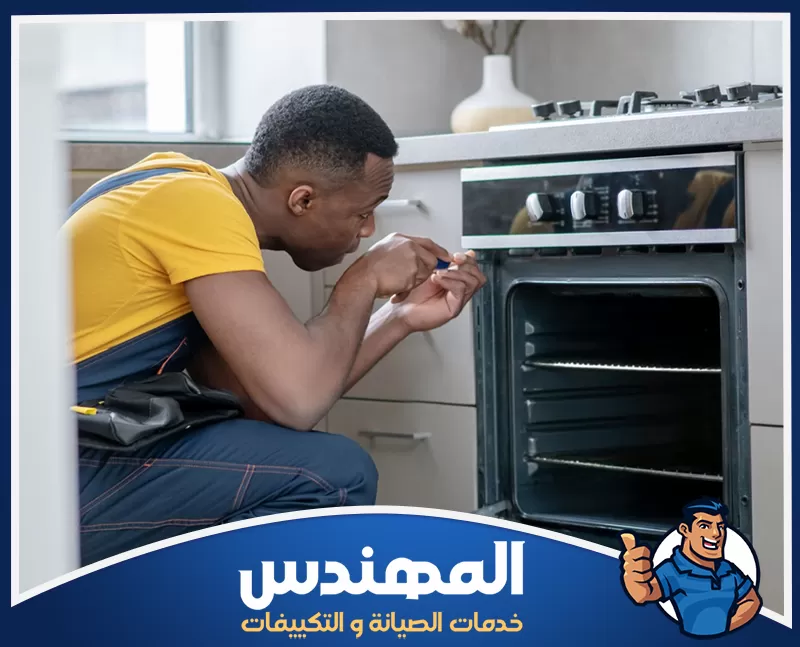 تغيير زجاج باب الفرن بحفر الباطن 0546176127 المهندس فني يفحص لوحة تحكم فرن منزلي ويصلح الأزرار باستخدام مفك يدوي.